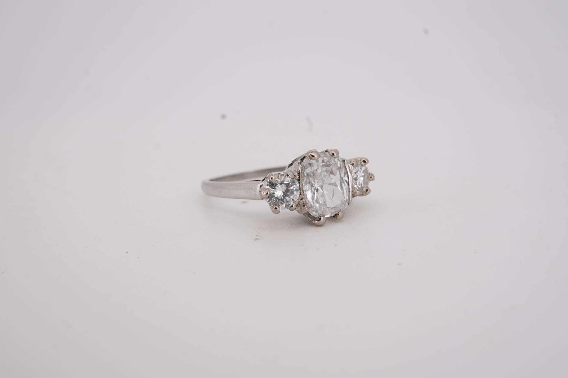 A diamond ring, set with a cushion-shaped diamond weighing 1.50 carats, between shoulders set with brilliant-cut diamonds totalling approximately 0.40 carats, size K, gross weight approximately 4 grams, Condition: centra